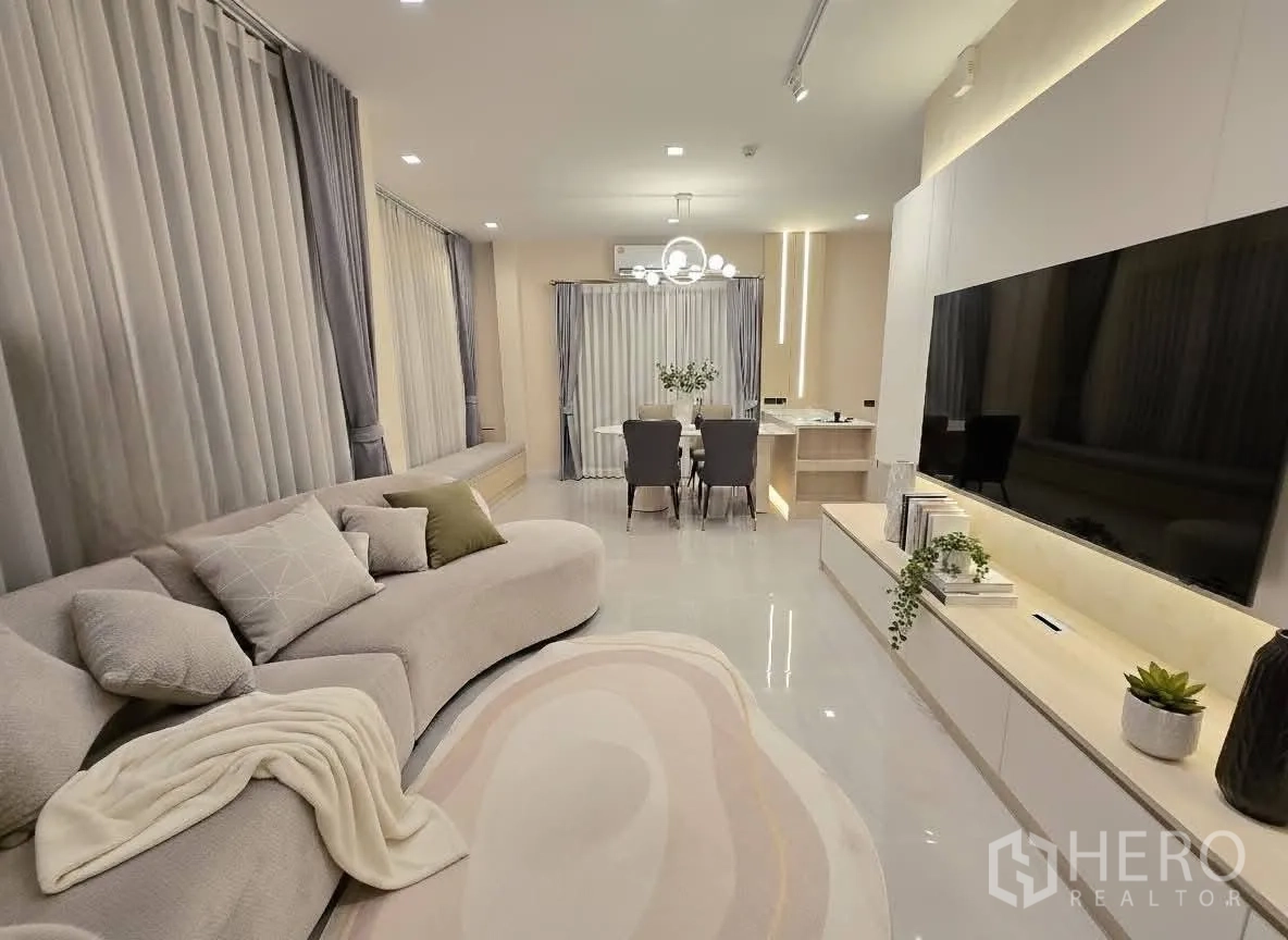บ้าน for rent or sale in Bang Phli, Samut Prakan - ห้องนั่งเล่นกว้าง โซฟาโค้ง ตู้วางทีวียาว และพื้นเงางาม