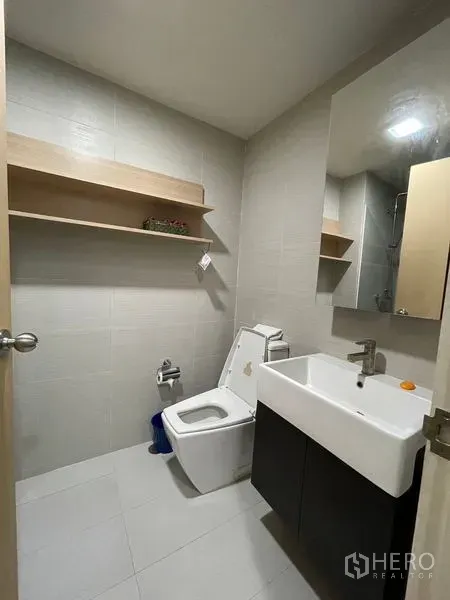 คอนโด ขายในKhlong Toei, Bangkok - ห้องน้ำสะอาด มีอ่างล้างหน้า กระจกบานใหญ่ โถสุขภัณฑ์ และชั้นวางของลอย