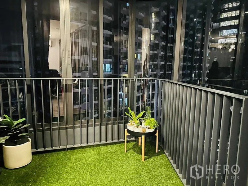 คอนโด ให้เช่าในHuai Khwang, Bangkok - ระเบียงยามค่ำคืน พื้นหญ้าเทียม กระถางต้นไม้ และตึกสูง