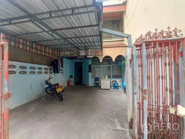 ทาวน์เฮาส์ ให้เช่า - ลานหน้าบ้านมีกันสาดโลหะ จอดรถได้ พร้อมซุ้มโค้งและประตูรั้วเหล็ก