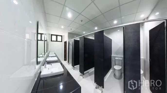 工厂 出租在Samut Prakan - 现代卫生间，多间隔断与长台面洗手盆，顶灯明亮