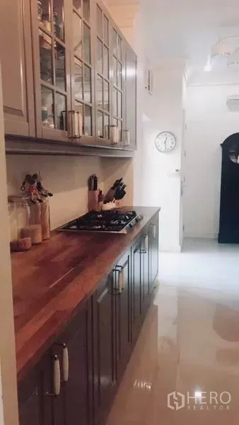 ทาวน์เฮาส์ ให้เช่าหรือขายในBangkok - ครัวรูปตัวแคบ เคาน์เตอร์ไม้ เตาแก๊ส และตู้กระจก พร้อมพื้นแวววาว