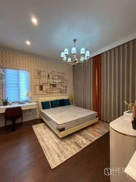 Detached House for sale in Bang Kapi, Bangkok - Bedroom with work desk, chandelier, patterned wallpaper and blackout curtains.