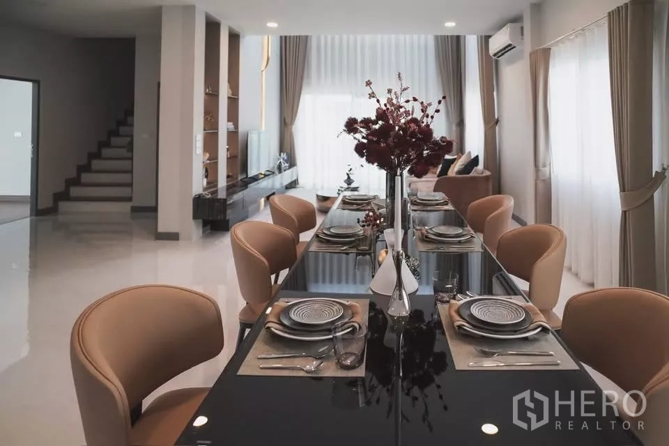 Detached House for rent in Bang Phli, Samut Prakan - Elegant dining room with long glossy table set for eight, open to the living space.