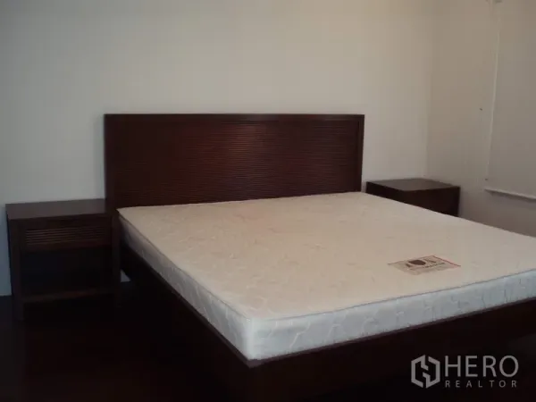 คอนโด ให้เช่าในRatchathewi, Bangkok - ห้องนอนกว้าง เตียงไม้พร้อมที่นอนและโต๊ะข้างเตียงคู่ ในคอนโดย่านราชเทวี