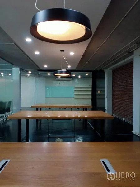 办公空间 出租在Khlong Toei, Bangkok - 接待区，服务台、红砖特色墙与工业风灯具。