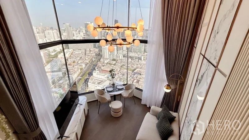 Condominium for rent - View from the mezzanine down to the living room with globe chandelier and panoramic windows over the city.