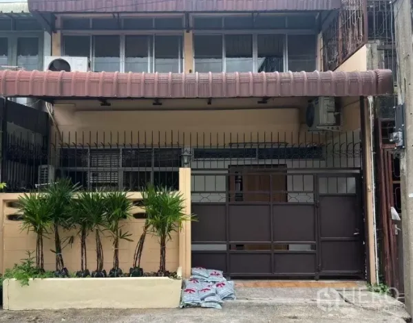 联排别墅 出租 - 两层联排别墅外观，带铁门车位和棕榈绿化。