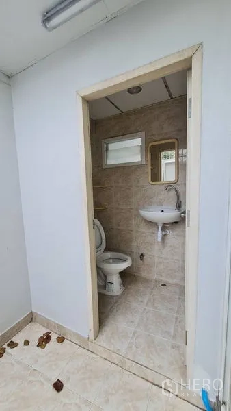 Shophouse for rent - Tiled bathroom with toilet, sink, mirror and small window