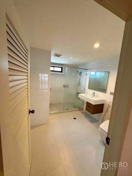 公寓 出租在Bangkok - 明亮浴室，玻璃淋浴间、壁挂洗手台与坐便器
