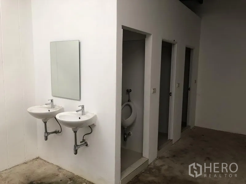 工厂 出租或出售在Bang Phli, Samut Prakan - 厂区卫生间，双挂墙洗手盆与独立隔间。