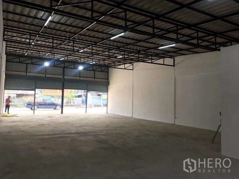 คลังสินค้า ให้เช่าในLam Luk Ka, Pathum Thani - มุมมองจากในโกดังออกสู่หน้าร้าน มีประตูม้วนหลายบานและแสงสว่างเพียงพอ.