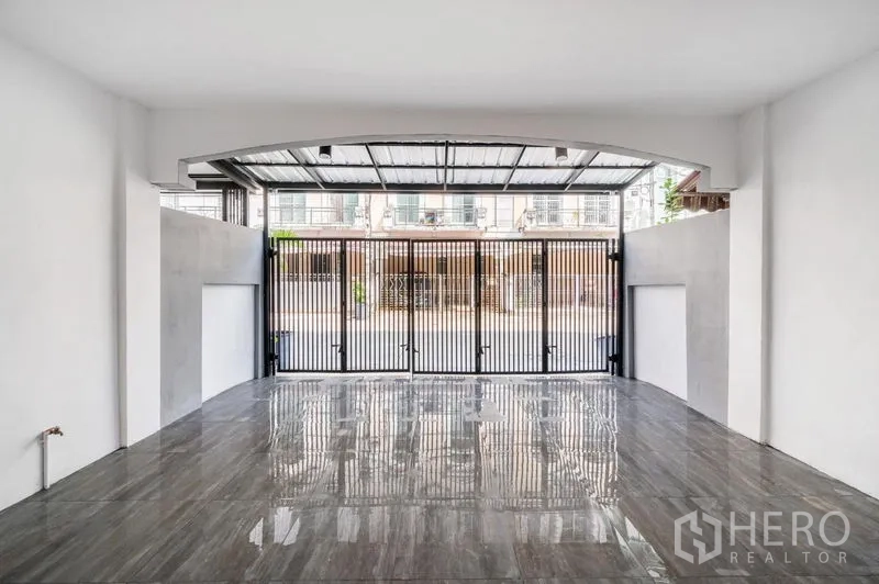 ทาวน์เฮาส์ ขาย - มุมมองจากในโรงจอดรถ พื้นกระเบื้องเงาและประตูพับเหล็ก