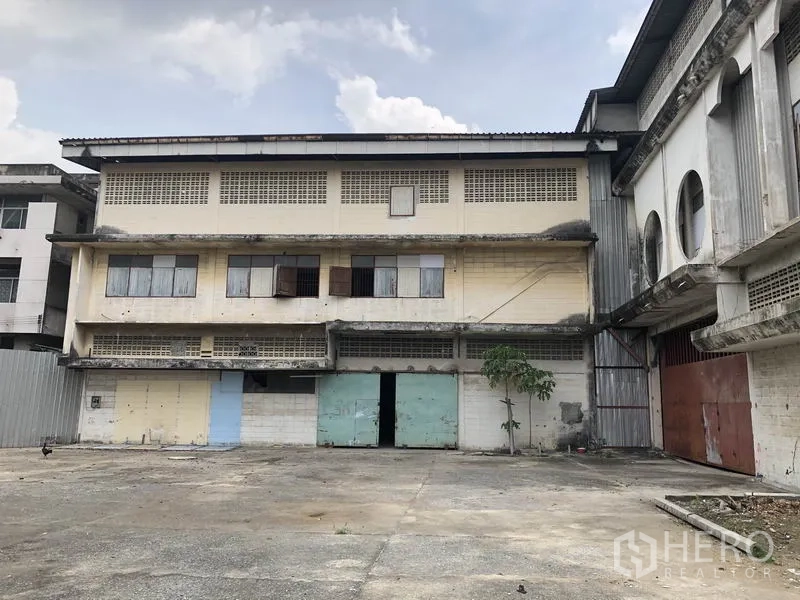 货栈 出租在Lak Si, Bangkok - 曼谷拉克西三层仓库立面，带装卸门与宽阔混凝土院坪。