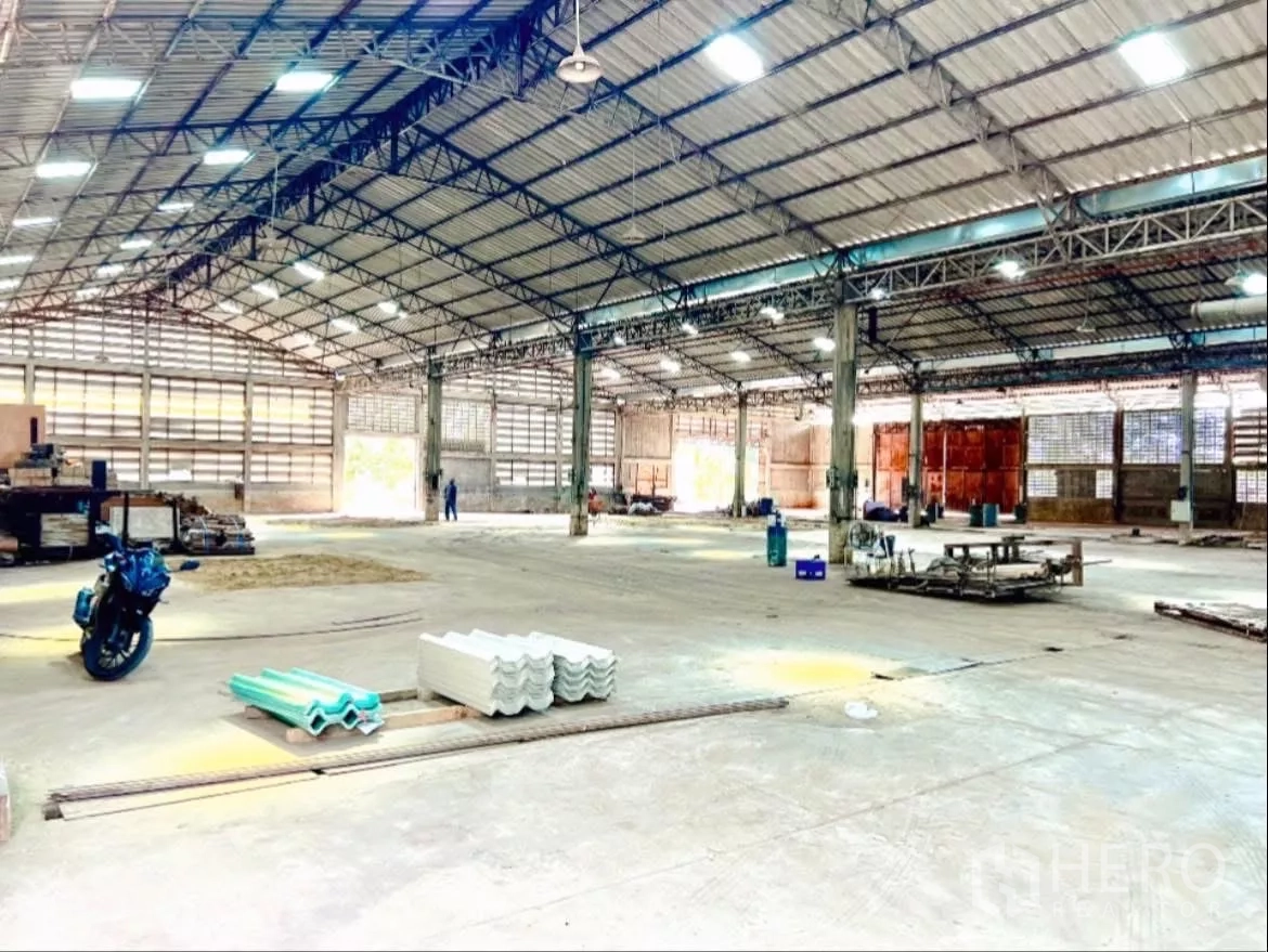 工厂 出租在Sai Noi, Nonthaburi - 大跨距厂房内部，宽阔柱距，远端为卷门。