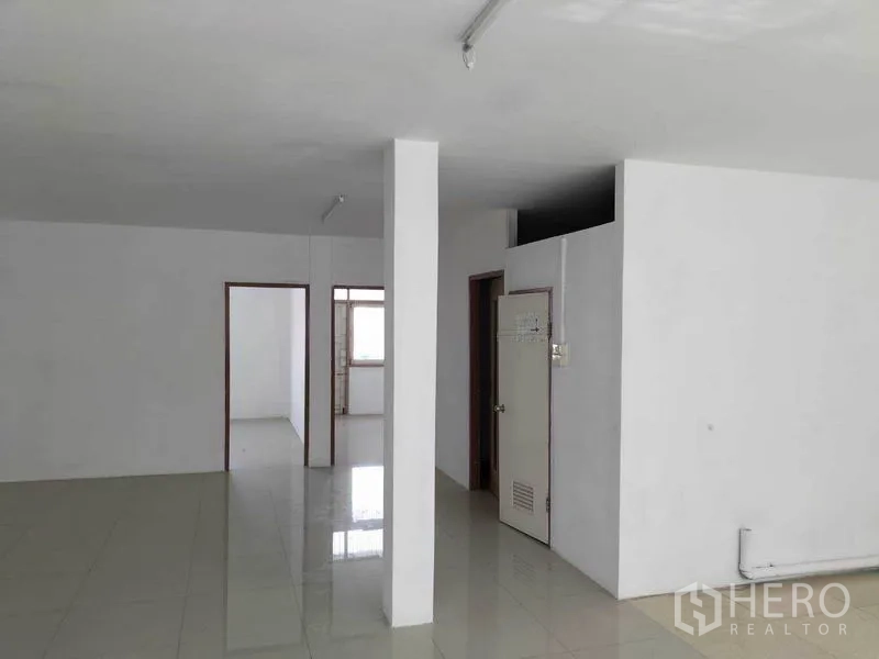 店屋 出租在Khlong Toei, Bangkok - 明亮开放楼层，瓷砖地面、白色立柱与室内卫生间区。