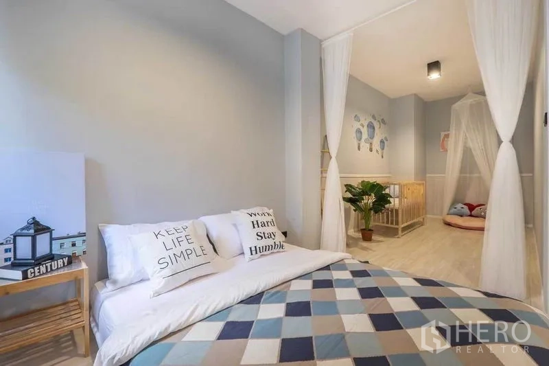 บ้าน ให้เช่าในKhlong Toei, Bangkok - ห้องนอนสีเทาอ่อน พร้อมเตียงและโซนเนอสเซอรี่ที่มีเตียงเด็กและมุ้ง