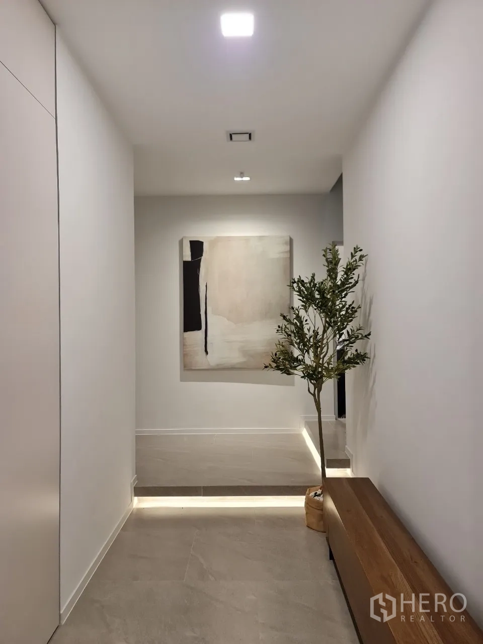 独立式住宅 出租在Saphan Sung, Bangkok - 极简走廊，挂画、长凳与阶梯氛围灯。