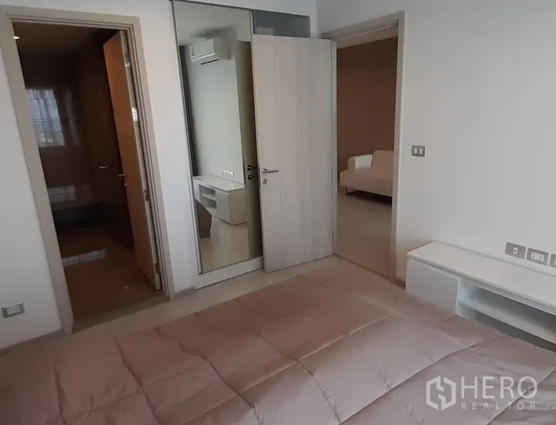 คอนโด ให้เช่าในKhlong Toei, Bangkok - ห้องนอนพร้อมตู้เสื้อผ้าบานกระจก ประตูเชื่อมเข้าห้องน้ำ และมุมมองไปยังห้องนั่งเล่น