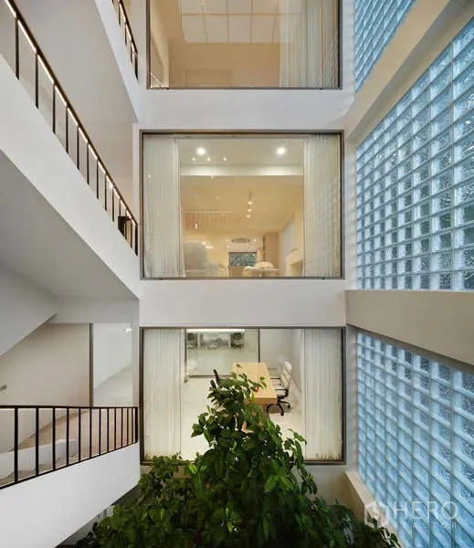 Home Office for sale in Chatuchak, Bangkok - Multi‑level atrium with glass‑block facade, interior windows and an indoor tree.