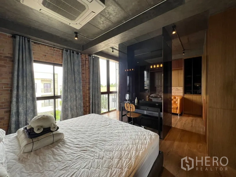 联排别墅 出租在Saphan Sung, Bangkok - 卧室转角，大窗、黑色玻璃隔断和小书桌。