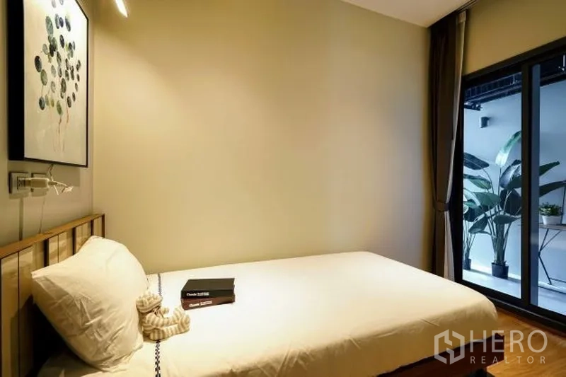 คอนโด ให้เช่าในWatthana, Bangkok - ห้องนอนที่สามขนาดกะทัดรัด เตียงเดี่ยว ประตูบานเลื่อนไปยังระเบียงพร้อมกระถางต้นไม้