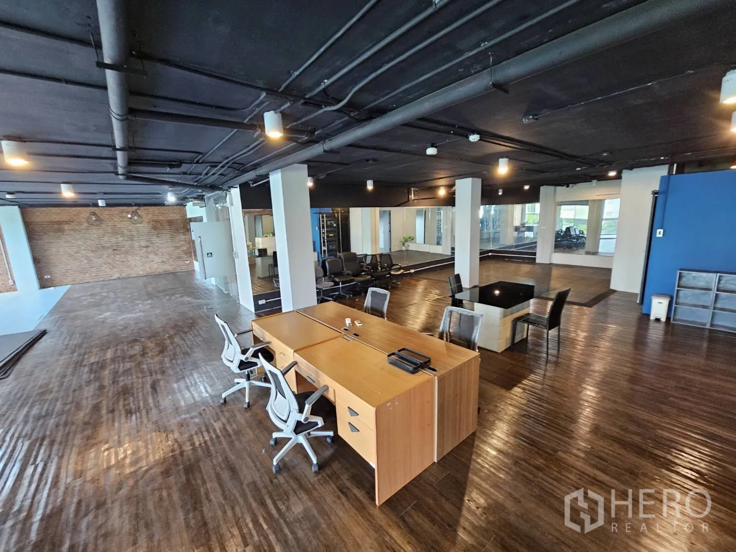 สำนักงาน ให้เช่าในWatthana, Bangkok - โซนทำงานร่วมกัน พื้นไม้ เพดานท่อเดินลอย โต๊ะทำงานและมุมนั่งประชุม.