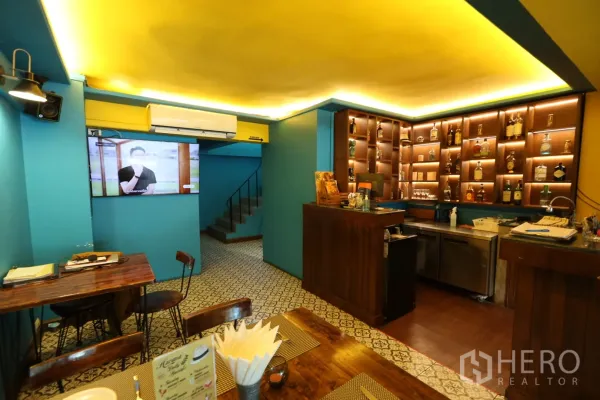 店屋 出租或出售在Khlong Toei, Bangkok - 楼梯旁小型就座区与电视，靠近服务吧台