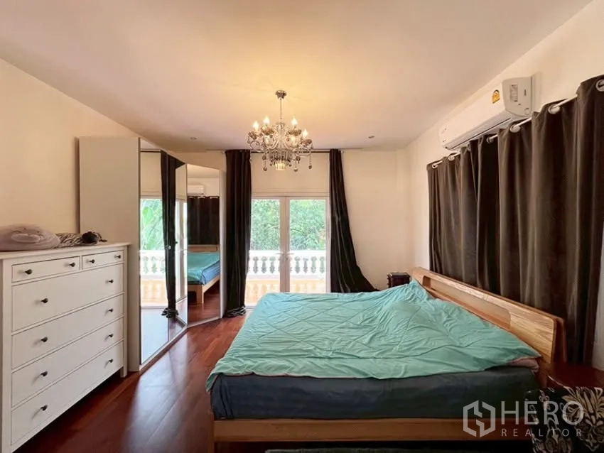 บ้านเดี่ยว for rent in Phra Khanong, Bangkok - ห้องนอนหลักมีโคมแชนเดอเลียร์ ผ้าม่านทึบ และทางออกไประเบียง