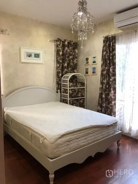 บ้าน ให้เช่าหรือขายในPrawet, Bangkok - ห้องนอนแขก เตียงสีขาว แชนเดอเลียร์ ผ้าม่านลายดอก และพื้นไม้