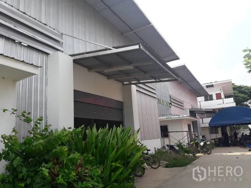 货栈 出租或出售在Khlong Luang, Pathum Thani - 仓库外立面，带雨棚的装卸口与车道出入。