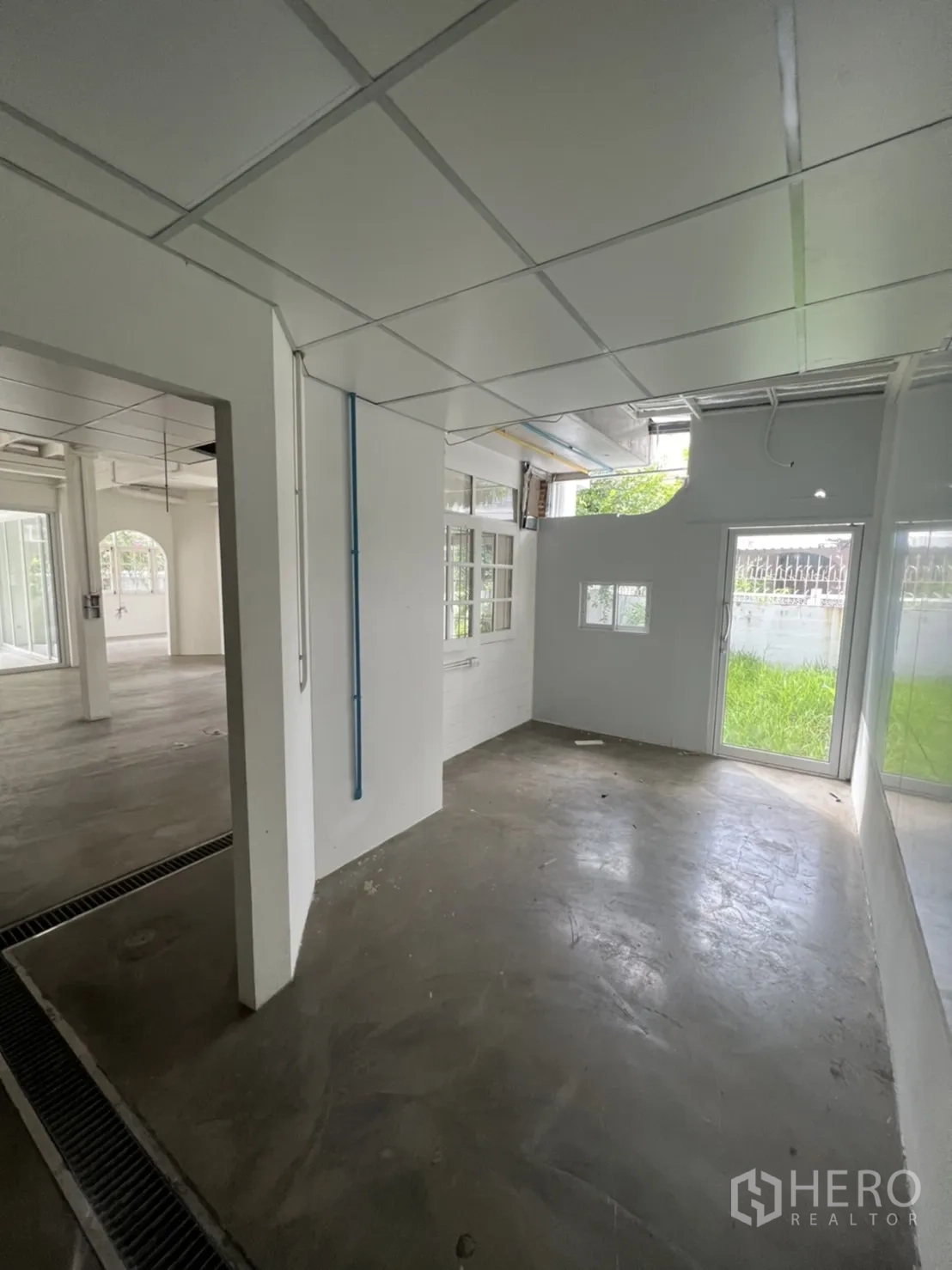 บ้าน ให้เช่าหรือขายในSathon, Bangkok - ห้องด้านข้างสว่าง พื้นคอนกรีต ประตูกระจกเลื่อนไปยังพื้นที่สีเขียว