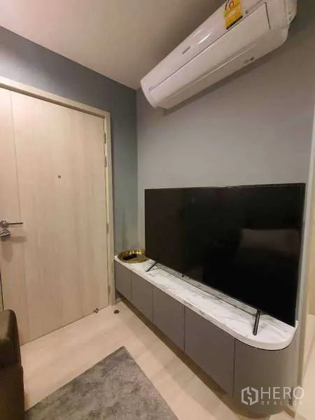 Condominium for rent - TV on a marble-top cabinet beneath an air conditioner near the entry door.