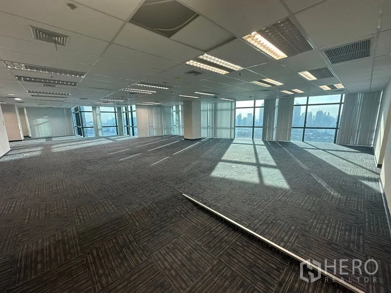 Office Space for rent in Watthana, Bangkok - Wide floor‑plate office with low‑glare lighting and city skyline at the windows.