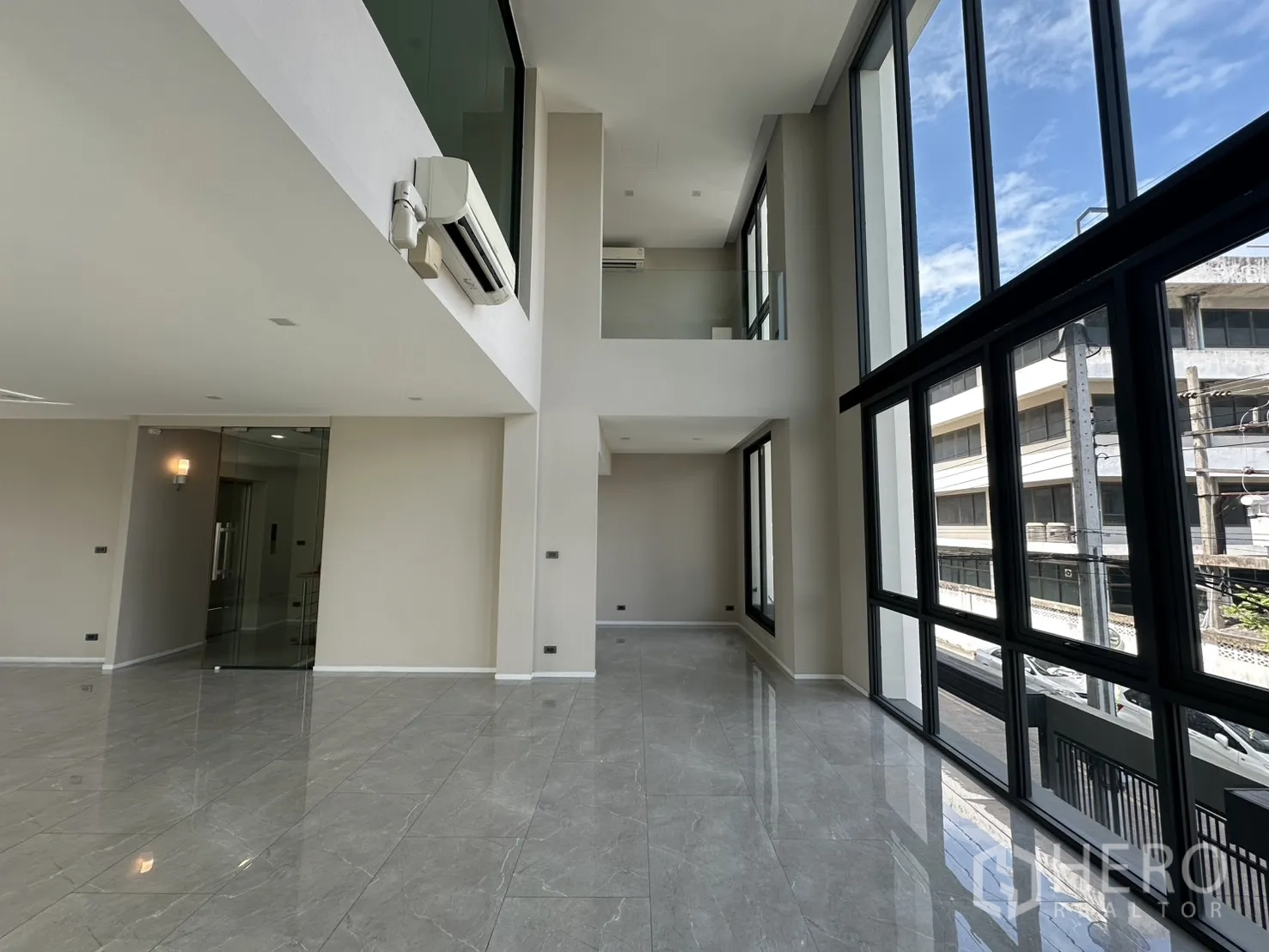 Home Office for rent or sale in Suan Luang, Bangkok - Tall windows flooding the open area with light and city views.