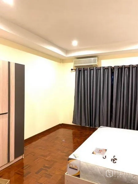 联排别墅 出租在Bang Na, Bangkok - 主卧宽敞，拼花木地板、空调、厚窗帘与衣柜。