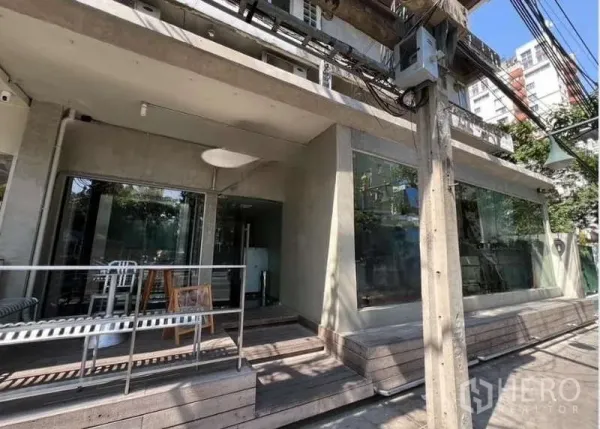 店屋 出租在Watthana, Bangkok - Watthana街边店屋外观，落地玻璃橱窗与带遮棚的木平台。