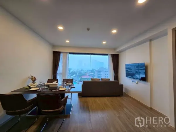 คอนโด ให้เช่าในPhaya Thai, Bangkok - ห้องนั่งเล่นและรับประทานอาหารแบบเปิดโล่ง มีหน้าต่างบานใหญ่ชมวิวเมือง พร้อมโซฟาและทีวีติดผนัง