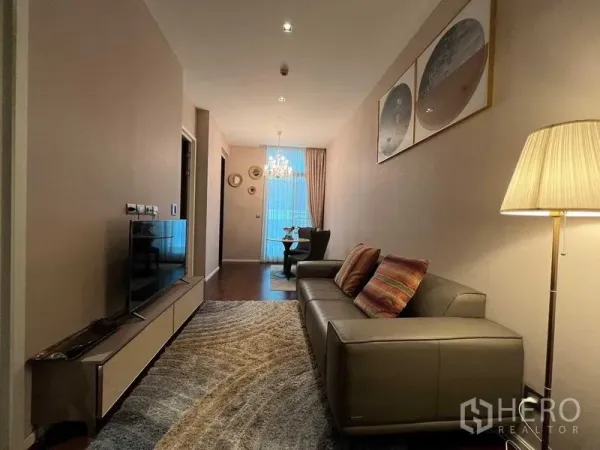 คอนโด ให้เช่าในWatthana, Bangkok - ห้องนั่งเล่นทรงลึก โซฟาหนัง ชั้นวางทีวี โคมไฟตั้งพื้น และมุมมองไปยังพื้นที่รับประทานอาหาร