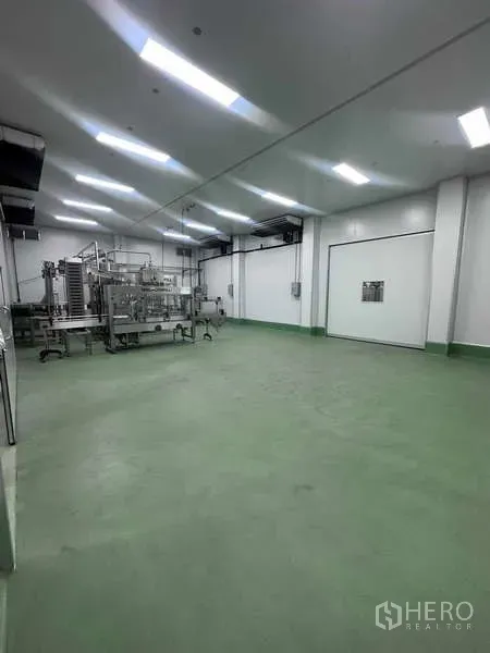 工厂 出租 - 宽敞洁净室，环氧地面，上方照明，配生产设备与白色保温门。