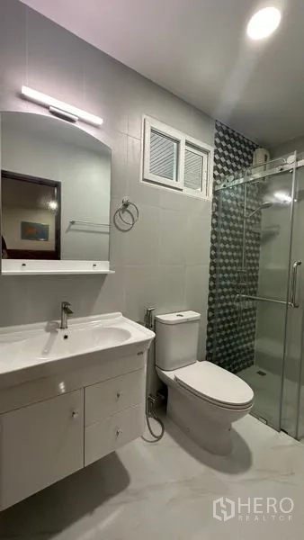 独立式住宅 出租在Watthana, Bangkok - 浴室配洗手台、特色墙砖与玻璃淋浴间。