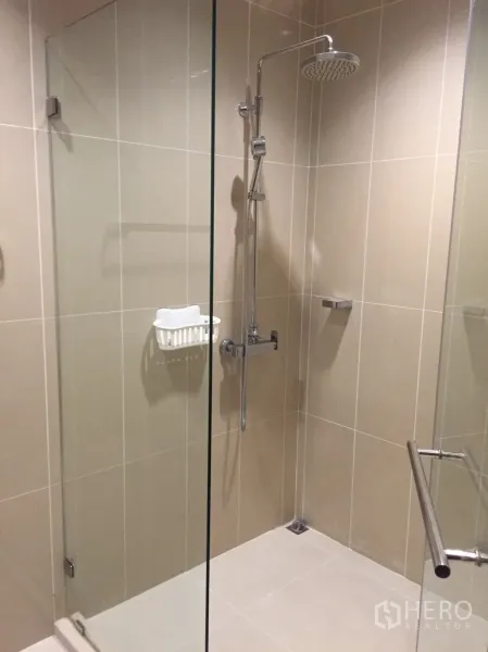คอนโด ขายในHuai Khwang, Bangkok - ห้องน้ำพร้อมตู้อาบน้ำกระจกและชุดฝักบัวเรนชาวเวอร์ กระเบื้องโทนอ่อน