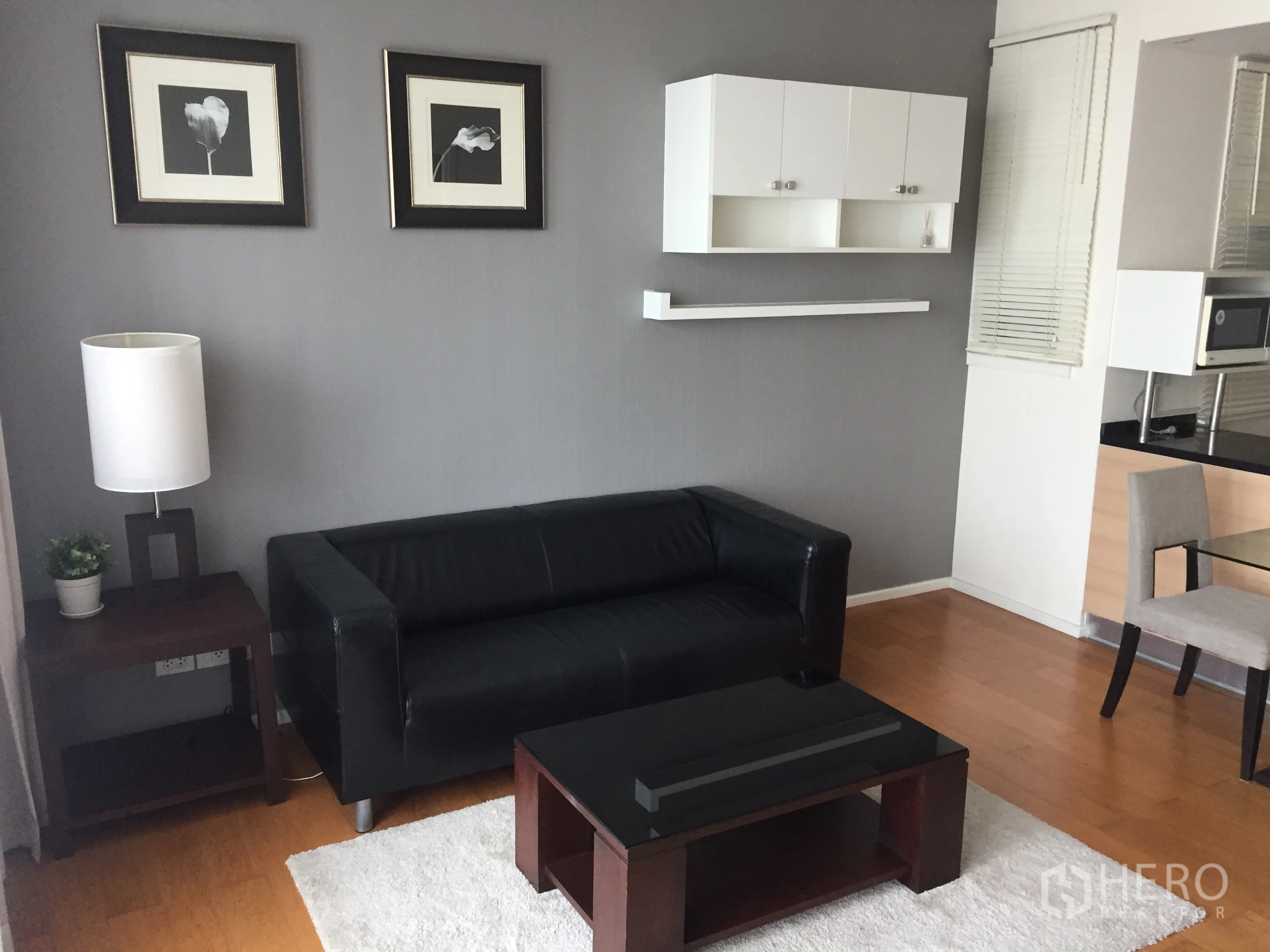 คอนโด ให้เช่าหรือขายในWatthana, Bangkok - มุมนั่งเล่นอบอุ่น โซฟาหนังสีดำ โต๊ะกลาง ผนังเทา และตู้แขวน