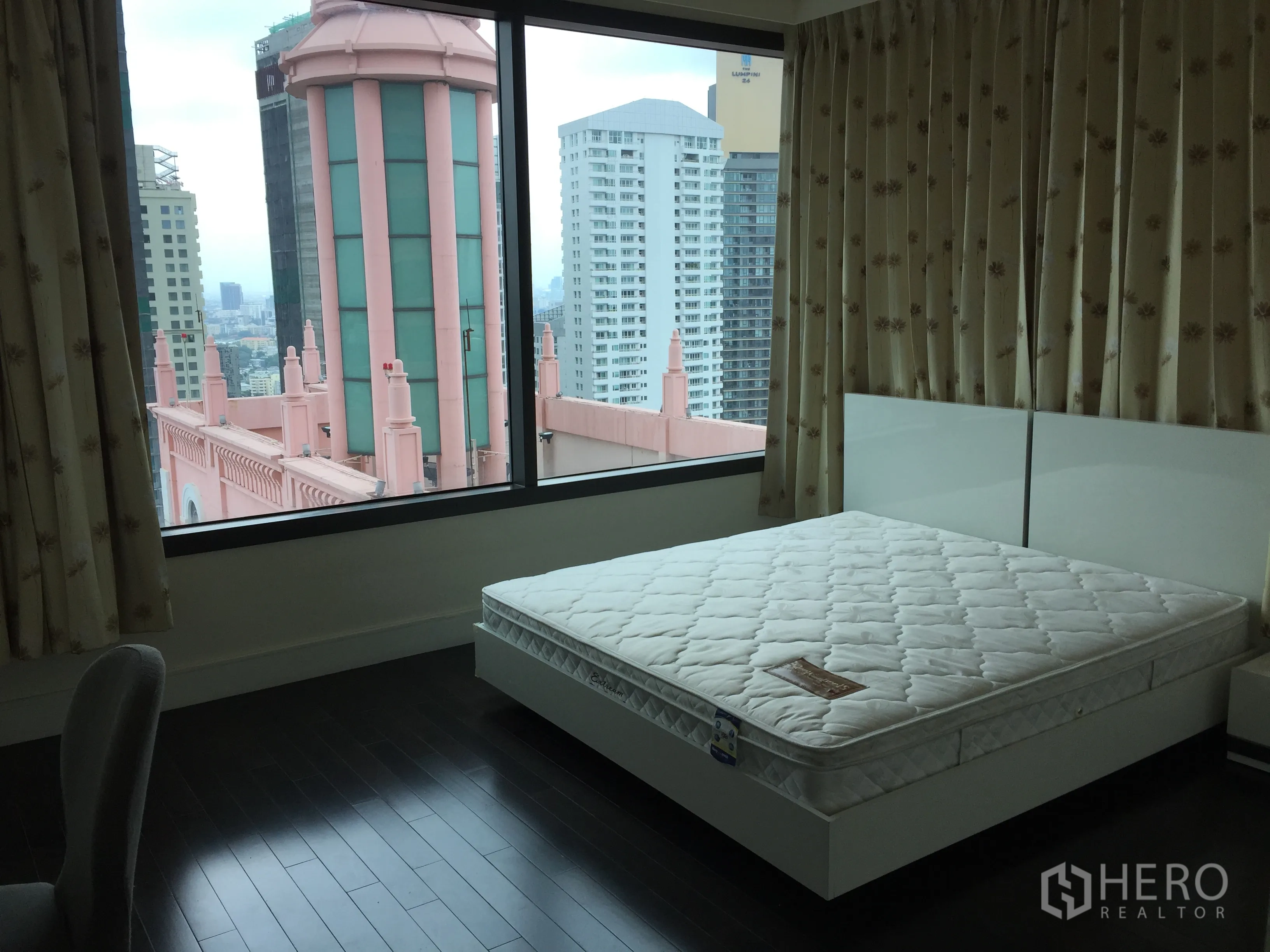 คอนโด ให้เช่าในKhlong Toei, Bangkok - ห้องนอนมุมกระจกบานใหญ่ มองเห็นวิวเมืองและอาคารหอคอยสีชมพูเด่น