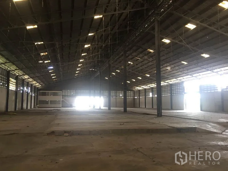Office Space for rent in Sai Noi, Nonthaburi - Expansive high-ceiling interior of a warehouse-style hall with open floor and side windows.
