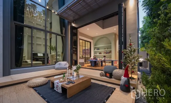 บ้าน ให้เช่าหรือขายในPhra Khanong, Bangkok - ชานบ้านไม้เชื่อมต่อห้องเล่นด้วยประตูพับ ไฟประดับและผนังกระจกสูง