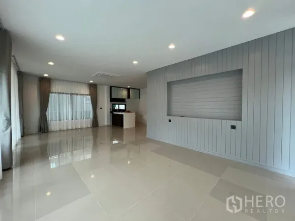 Detached House for rent in Bang Kapi, Bangkok - Bright open-plan living room with recessed lighting, large windows and a feature wall.