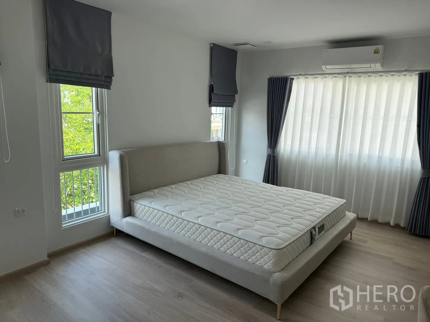 独栋房屋 for rent in Bang Phli, Samut Prakan - 转角卧室，灰色软包床，采光良好并配空调。