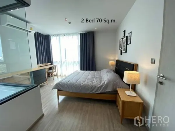 Condominium for rent in Watthana, Bangkok - Spacious bedroom with desk nook, bedside lamps and large windows in Khlong Tan Nuea condo.