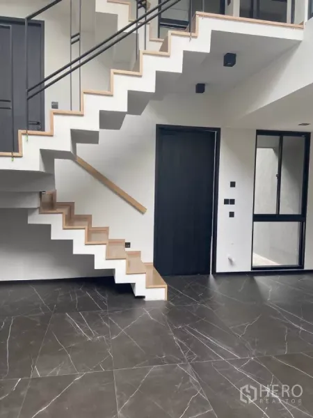 ทาวน์เฮาส์ ให้เช่าในHuai Khwang, Bangkok - บันไดลอยลูกนอนไม้สไตล์โมเดิร์นเหนือพื้นหินอ่อนสีดำเงา.